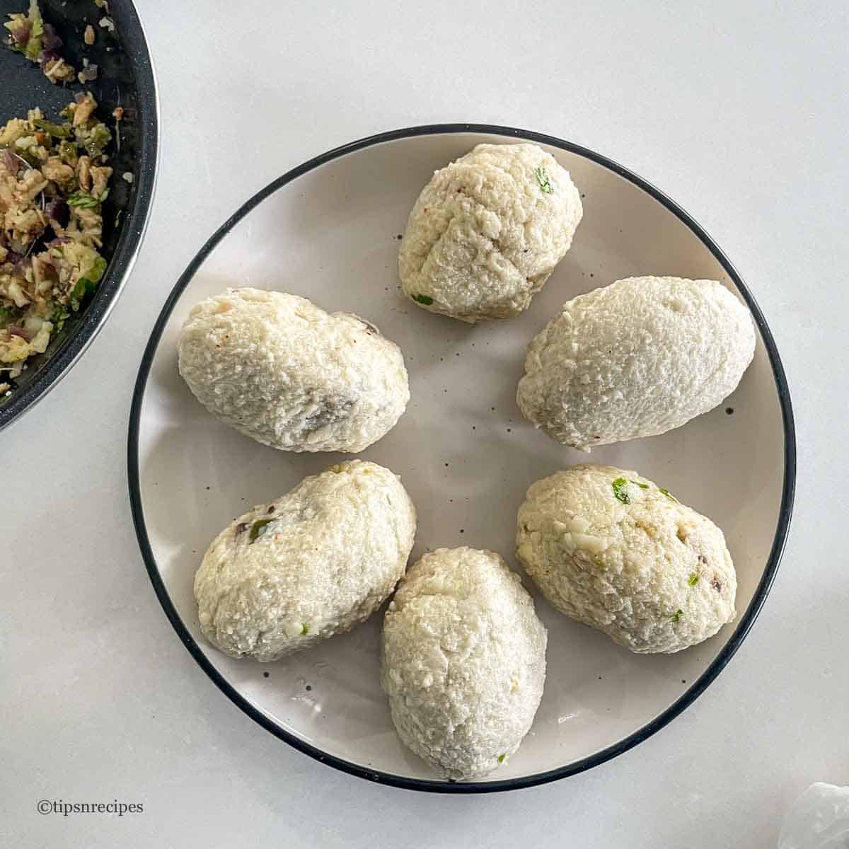 A palte of bread rolls stuffed with chicken filling.