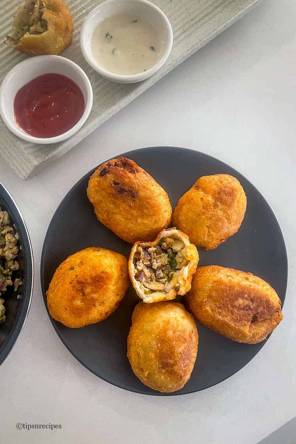 Crispy chicken bread rolls served with fresh dipping sauce, perfect for snacks or appetizers.