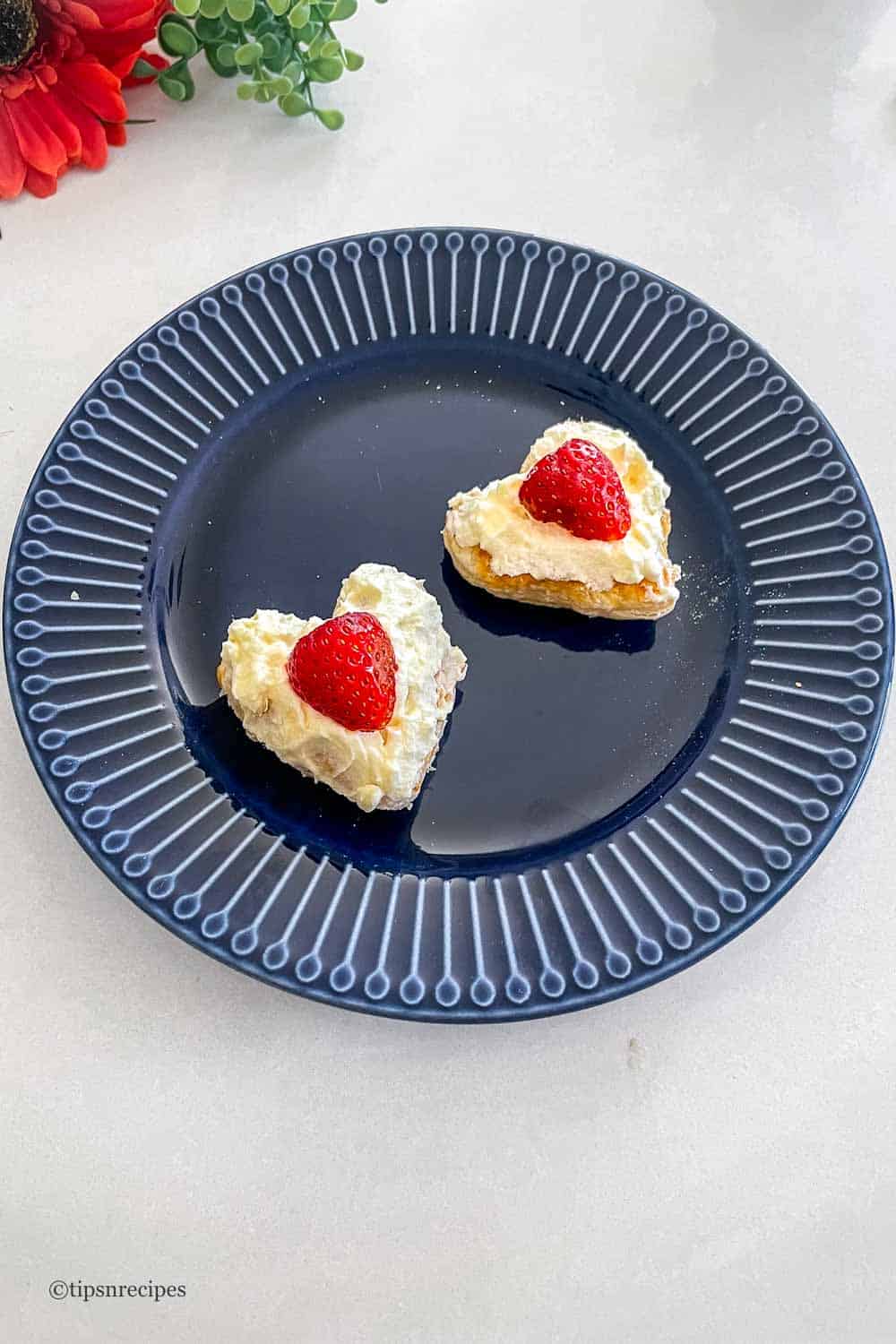 Heart pastry puff decorated with cream and strawberry.