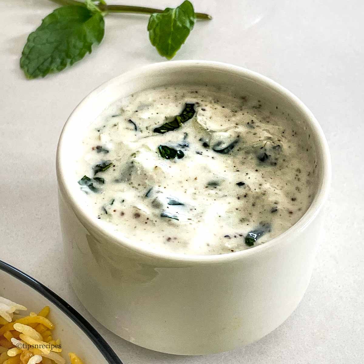 Creamy refreshing bowl of cucumber raita for biryani.