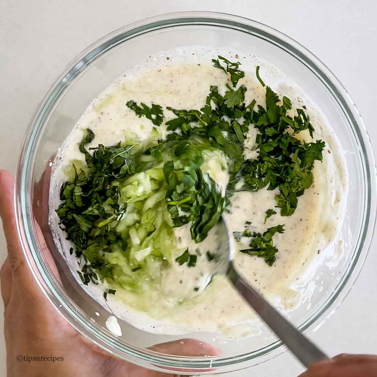 mixing of cucumber and other ingredients in a bowl.