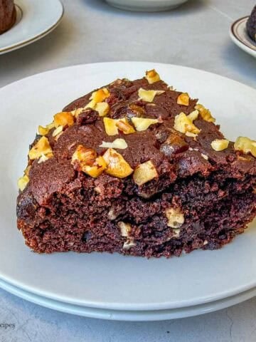 A slice of walnut date cake alom with a cup of tea.