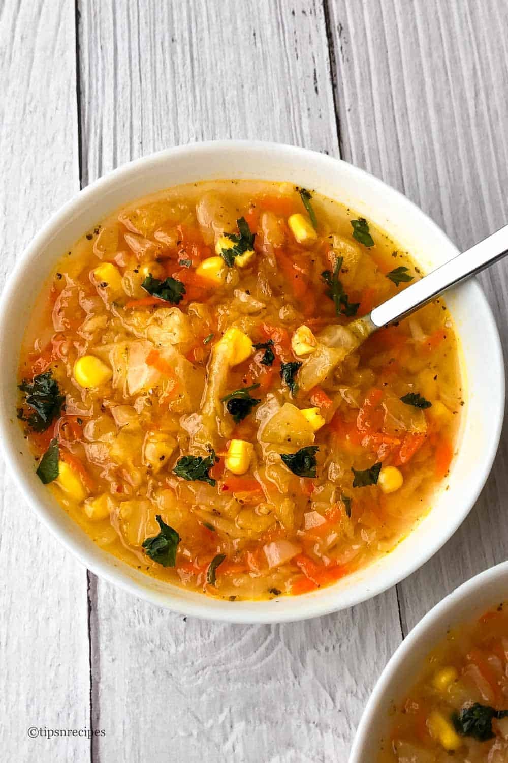 Bowls of carrot cabbage and corn soup.