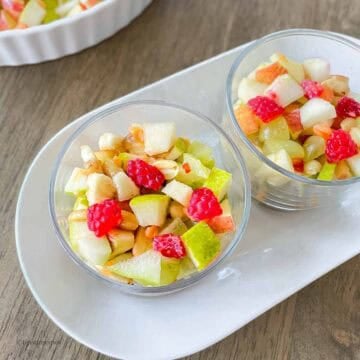 Bowls of freshly cut fruits with roasted peanuts.