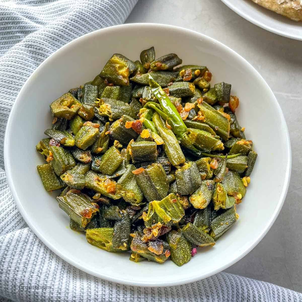 A bowl of frozen okra cooked in Indian style.