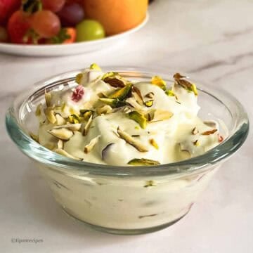 A bowl of refreshing fresh fruits with whipped cream.