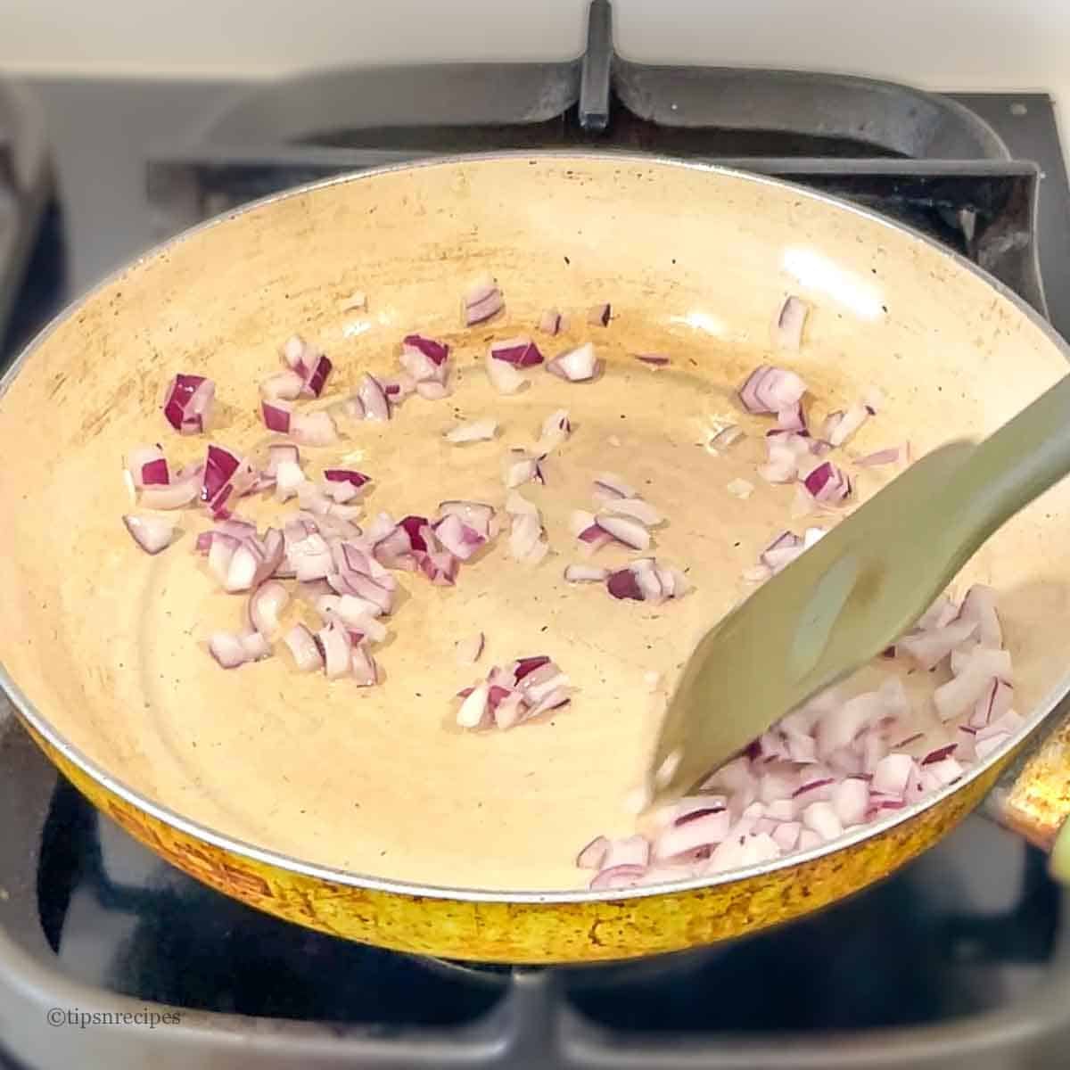 Cooking onions in a frying pan.