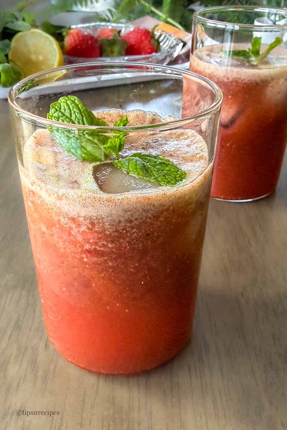 Two glasses of vibrant strawbeery mint drink.