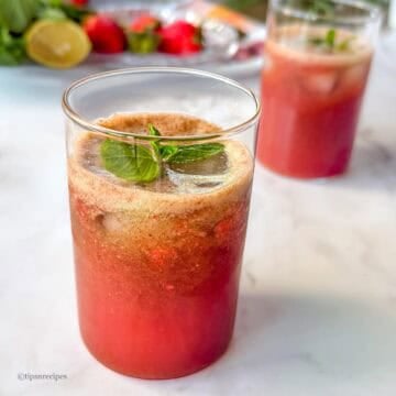 Vibrant summer strawberry mnit coooler in glasses ready to sip in.