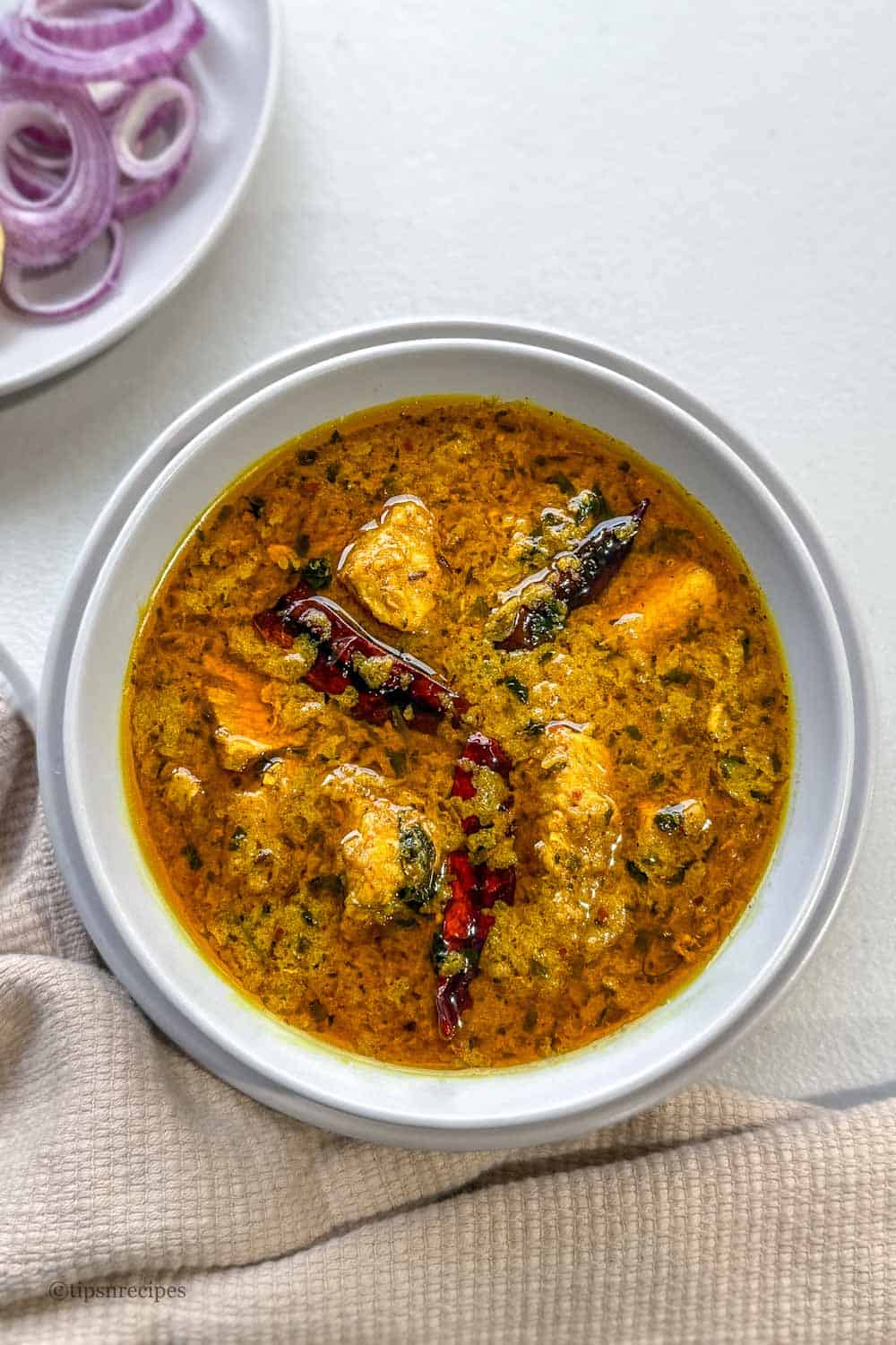 Spicy butter chicken curry bowl on dinner table.