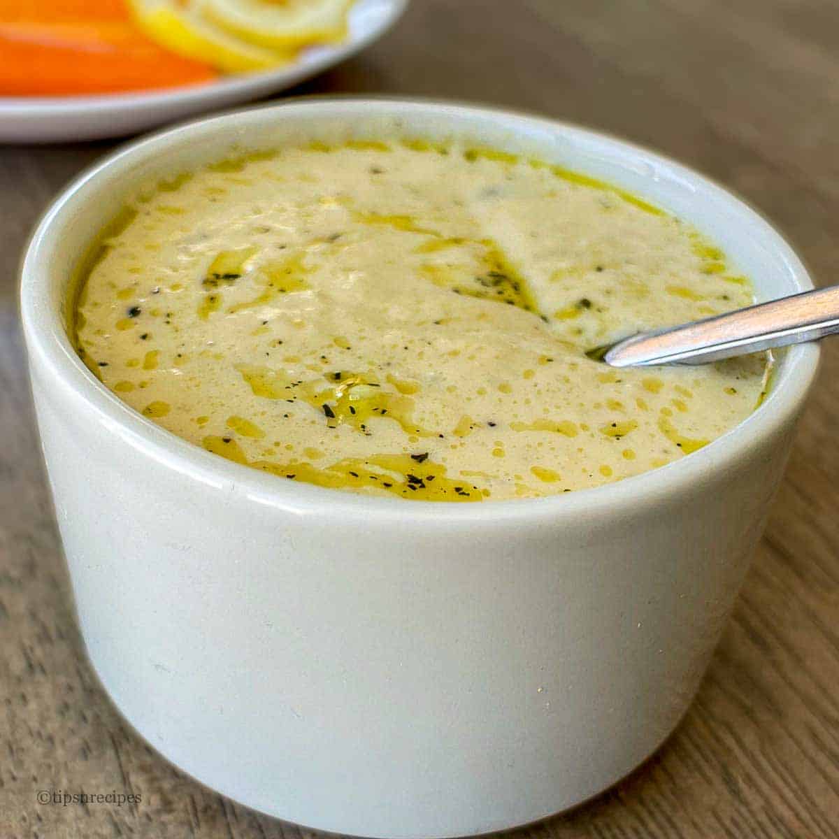 A hummus bowl with a spoon in it.