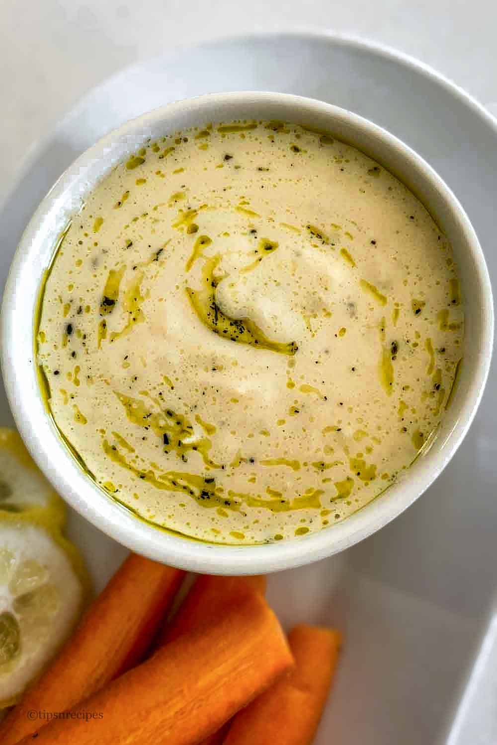 A bowl of hummus with vegetables.