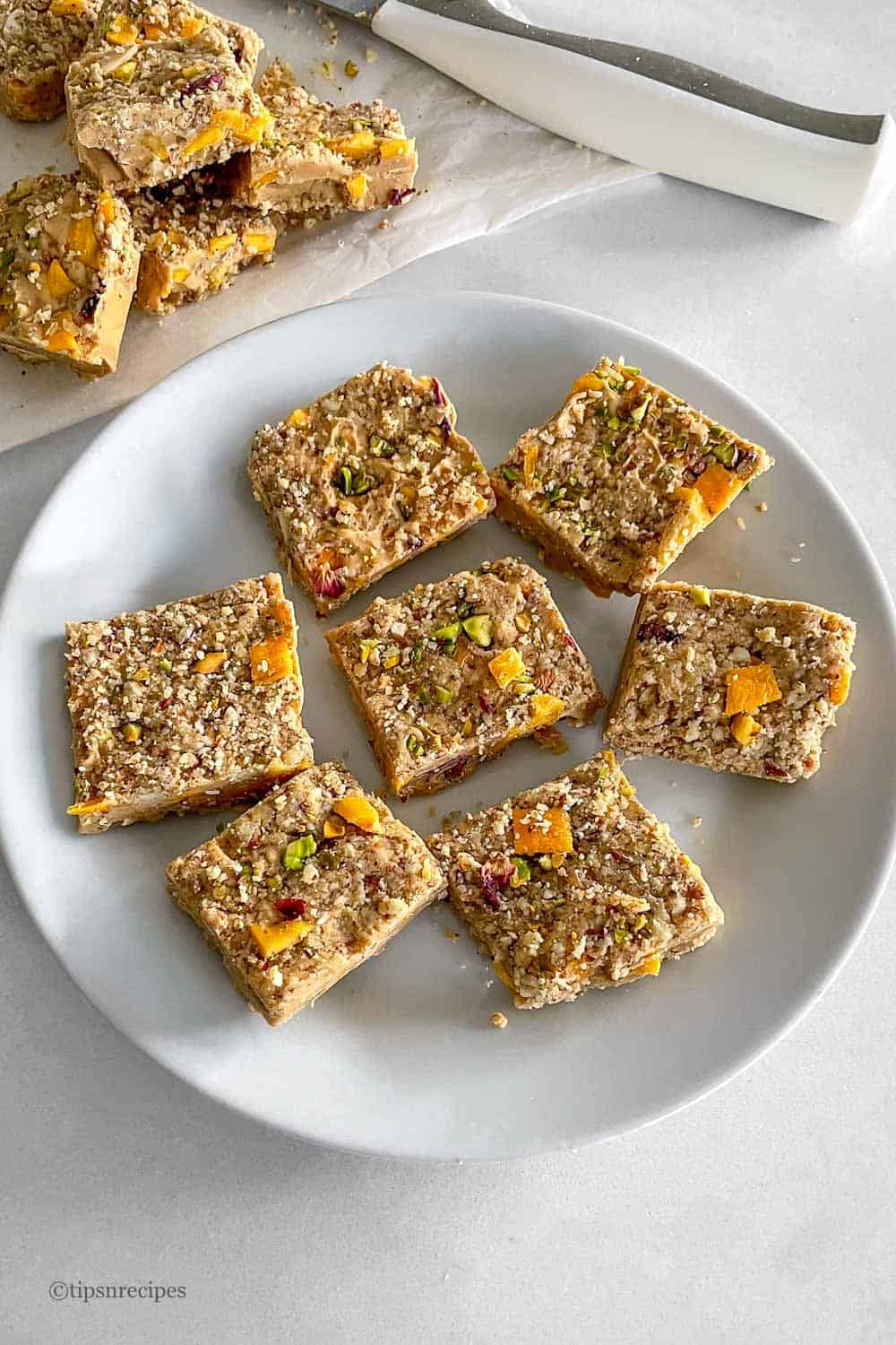 Mango and dry nuts slice barson a plate.