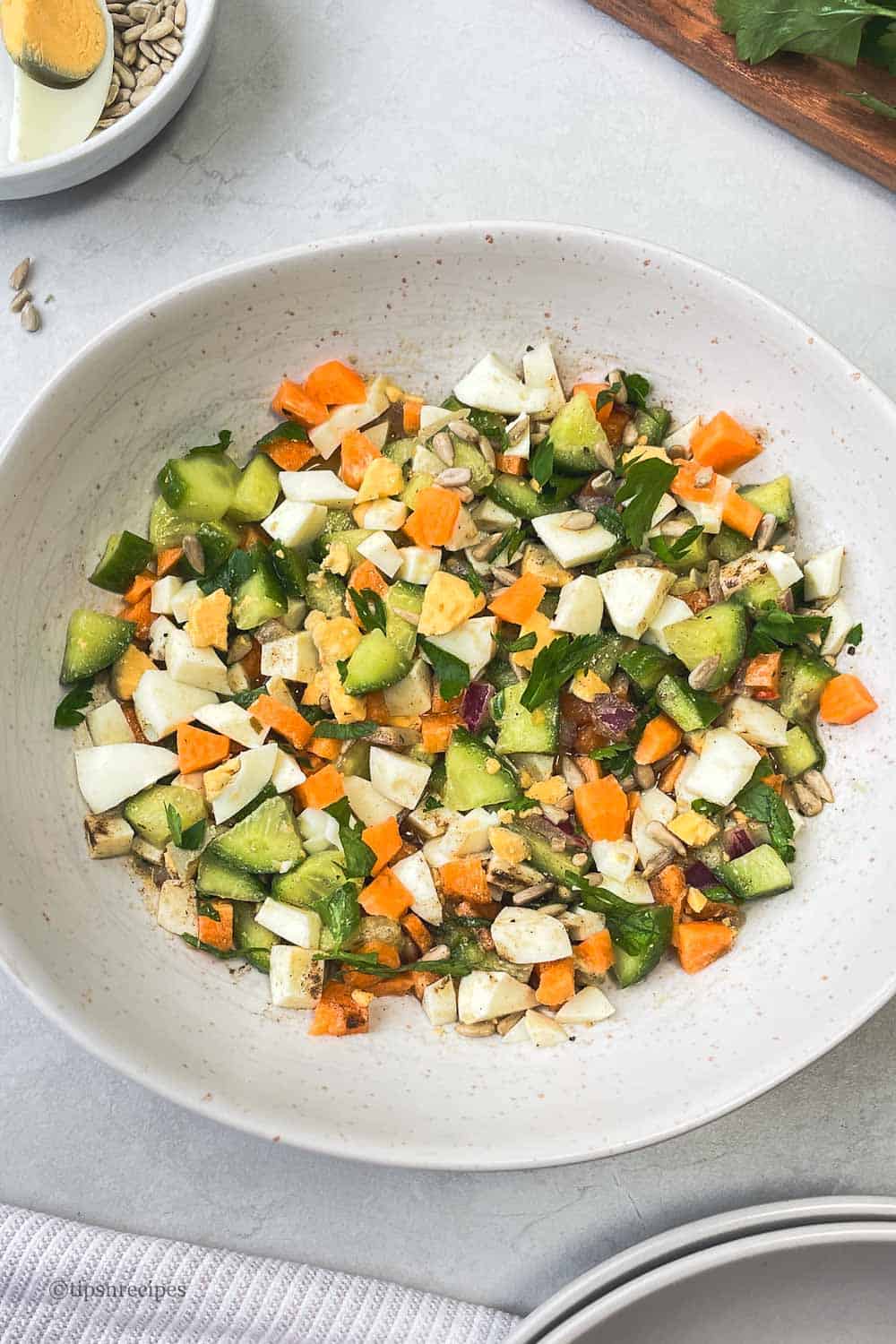 A bowl of freshly salad with eggs and vegetables.