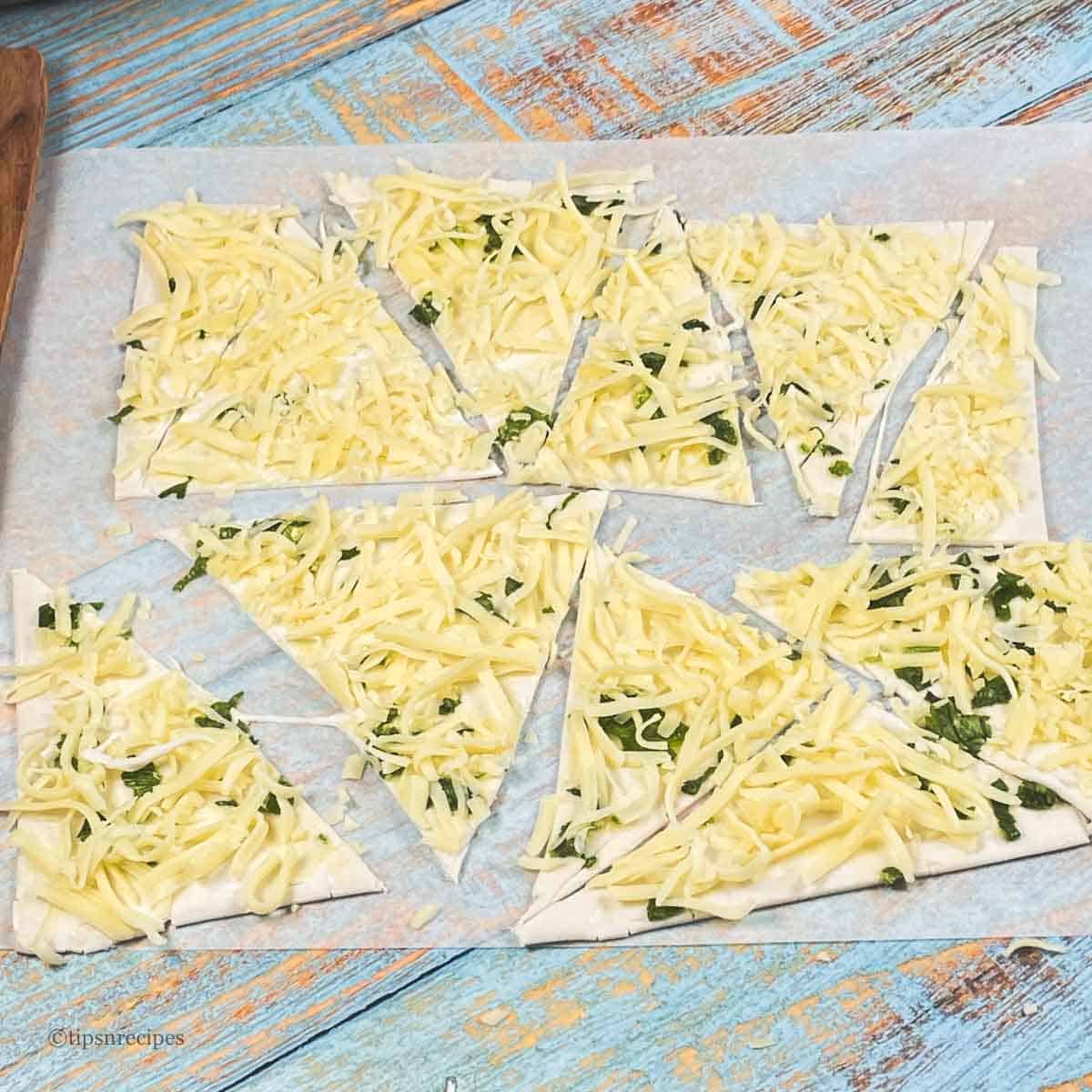 Pastry sheet with cheese cut into triangles.