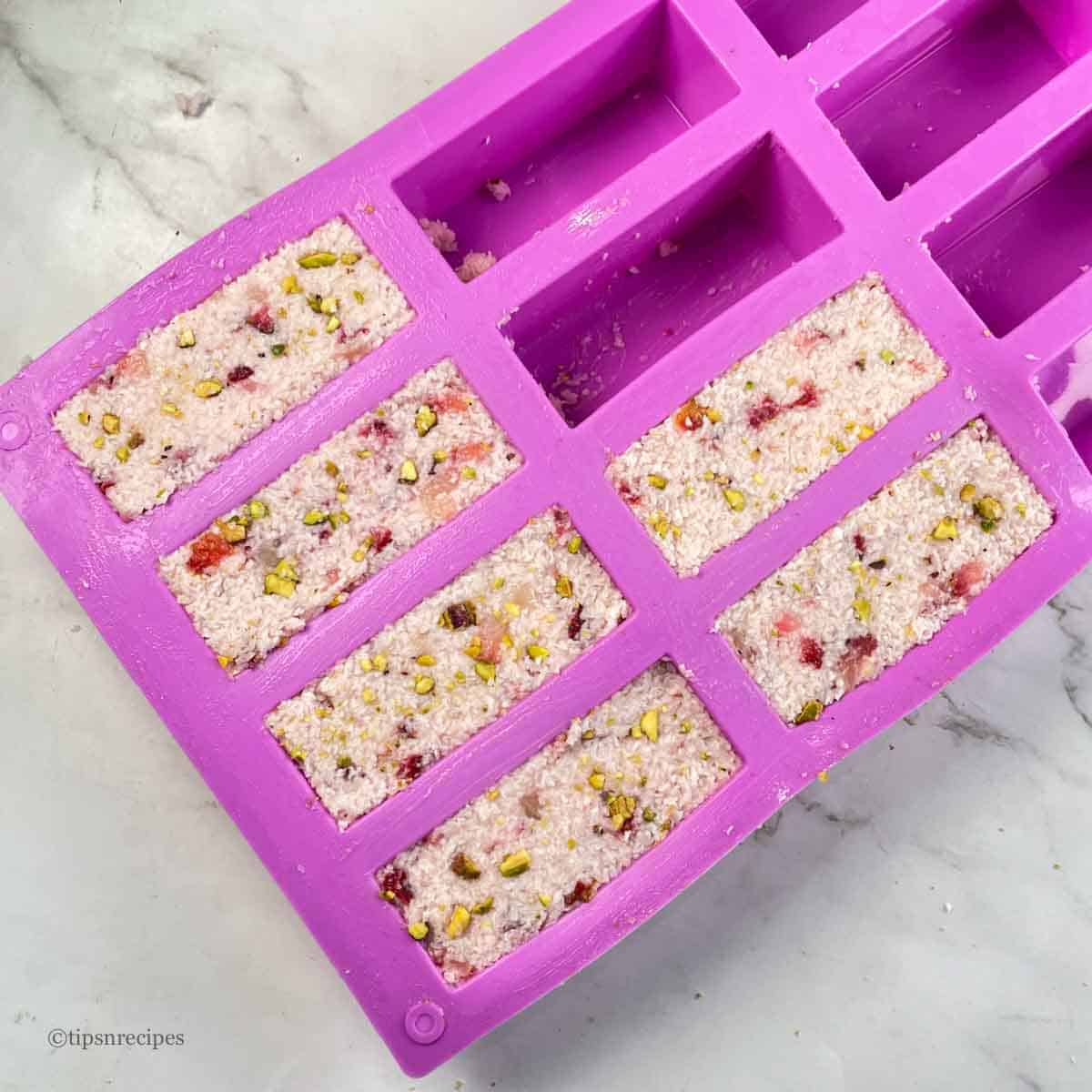 The coconut strawberry mixture transfered to silcone bars mould.
