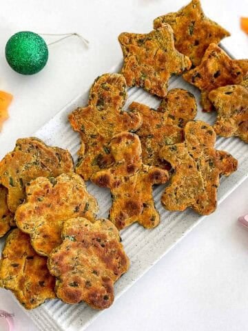 A white platter of crispy bites with autumn leaves and decorations.