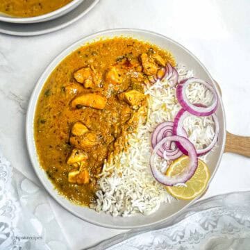 Spicy North Indian chicken curry served with rice and salad.